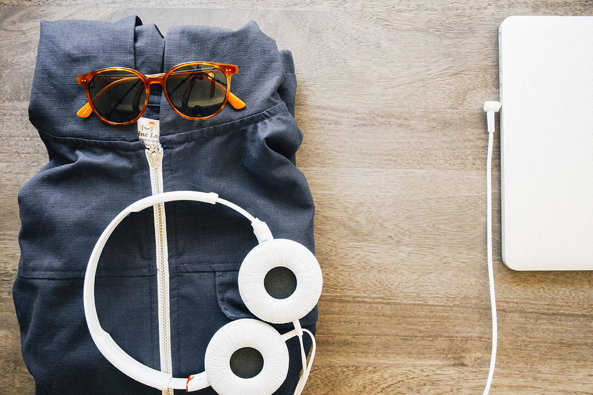 Flat lay of workout clothes and headphones on wooden floor.